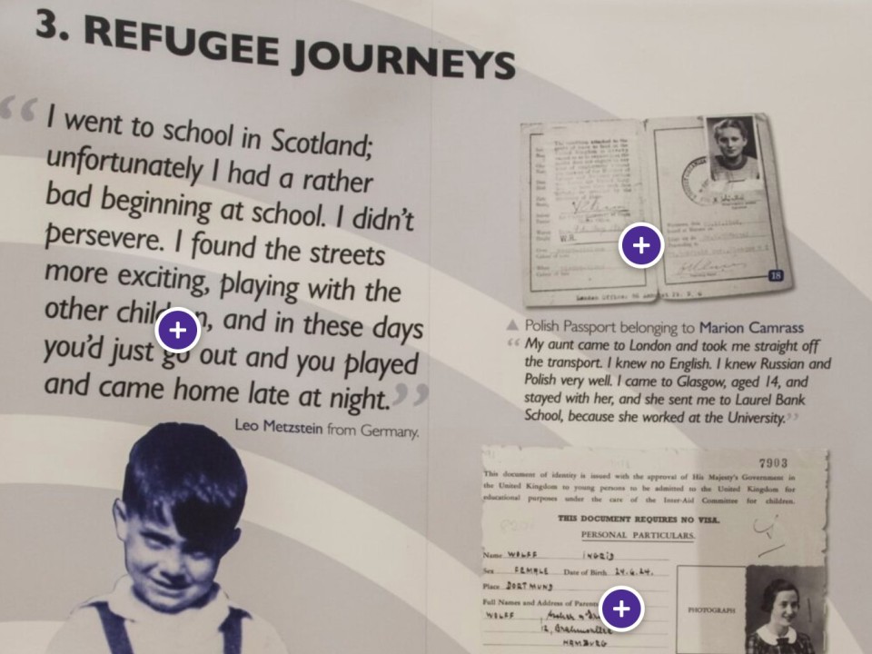 Exhibition panel titled Refugee journeys, with a quotation from Leo Metzstein, a Polish passport belonging to Marion Camrass and Ingrid Wuga’s visa card, each with a plus-shaped hotspot button.