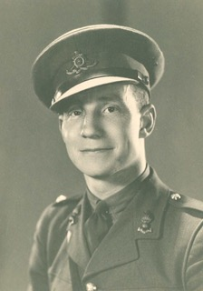 Sepia studio portrait of John J. Crosbie in British Army uniform and cap.