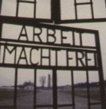 Iron gate bearing the words Arbeit macht frei at the entrance of a concentration camp.